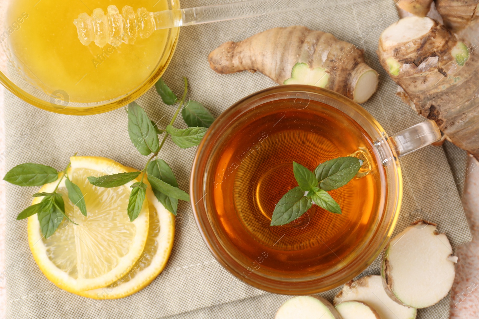 Photo of Flat lay composition of tea with mint, honey, lemon and ginger on table