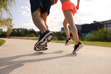 Photo of Healthy lifestyle. Couple running outdoors, low angle view