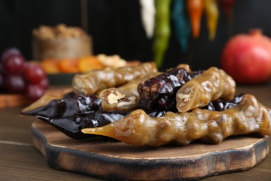 Photo of Many delicious sweet churchkhelas on wooden table, closeup