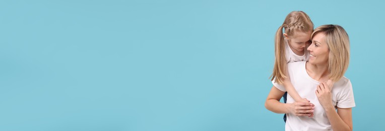 Image of Happy mother and daughter on light blue background, space for text. Banner design