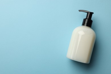Photo of Bottle of liquid soap on light blue background, top view. Space for text
