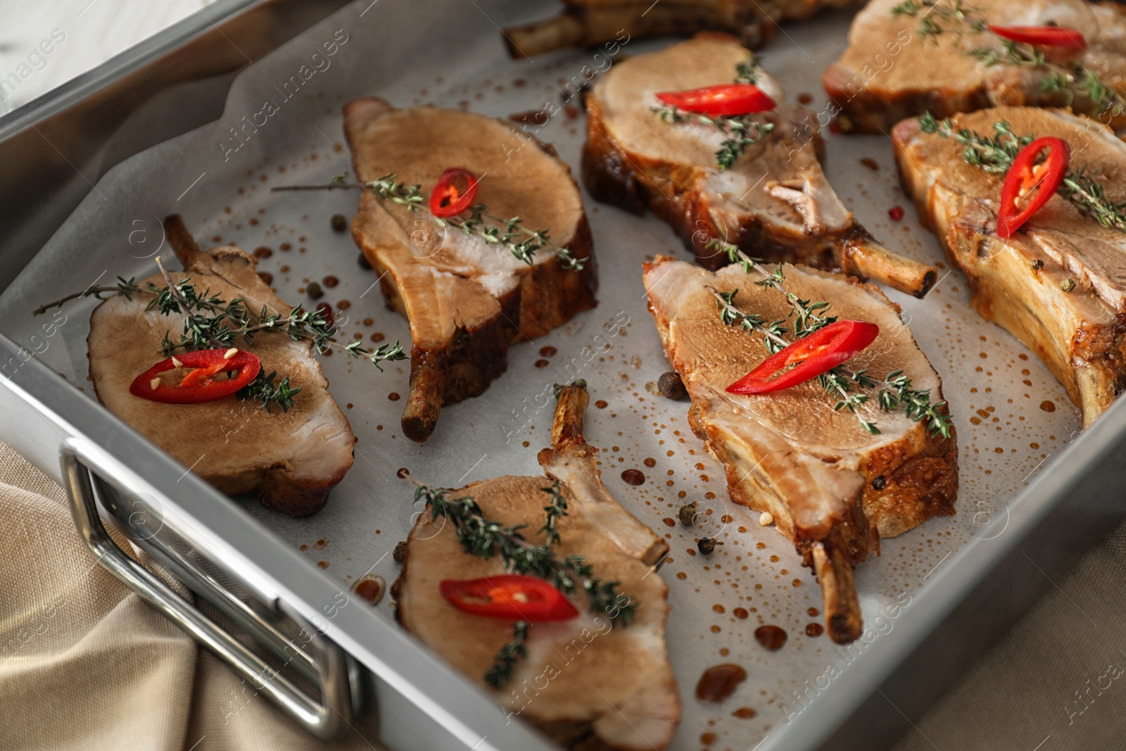 Photo of Delicious roasted ribs in baking tray, closeup