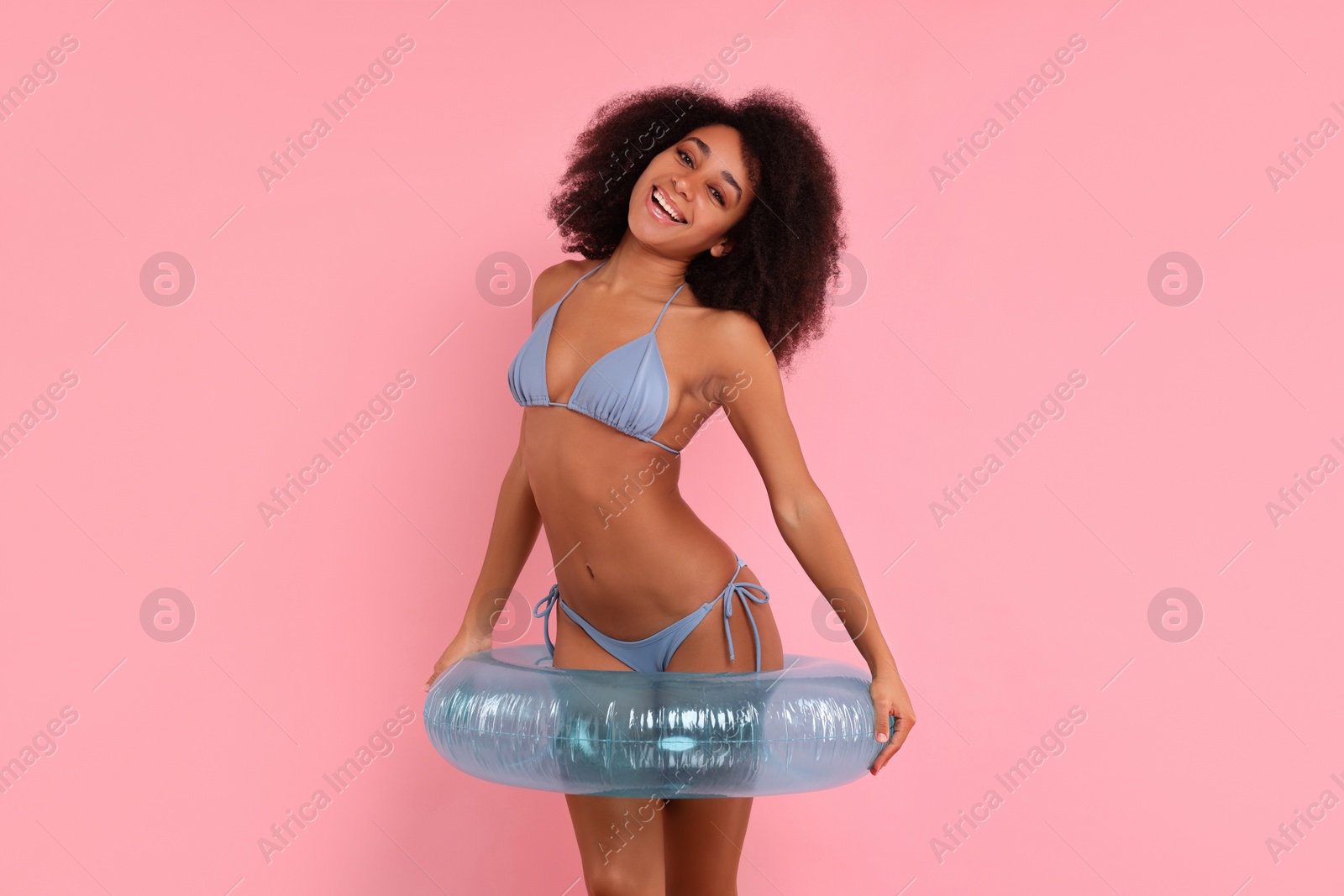 Photo of Beautiful woman in stylish bikini with inflatable ring on pink background