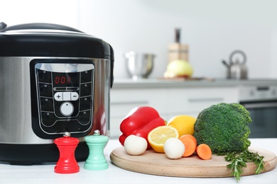 Modern multi cooker and products on kitchen table