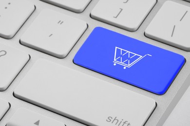 Online store. Blue button with shopping cart on computer keyboard, closeup