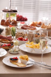 Photo of Variety of snacks on wooden table in buffet style indoors