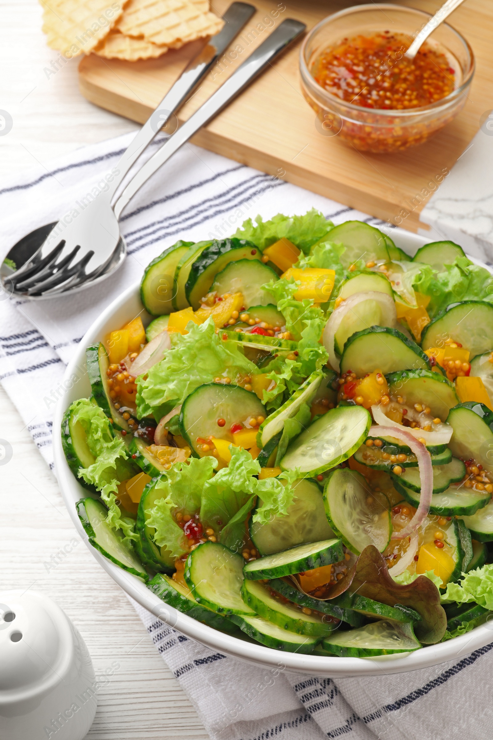 Photo of Delicious cucumber salad served on white wooden table