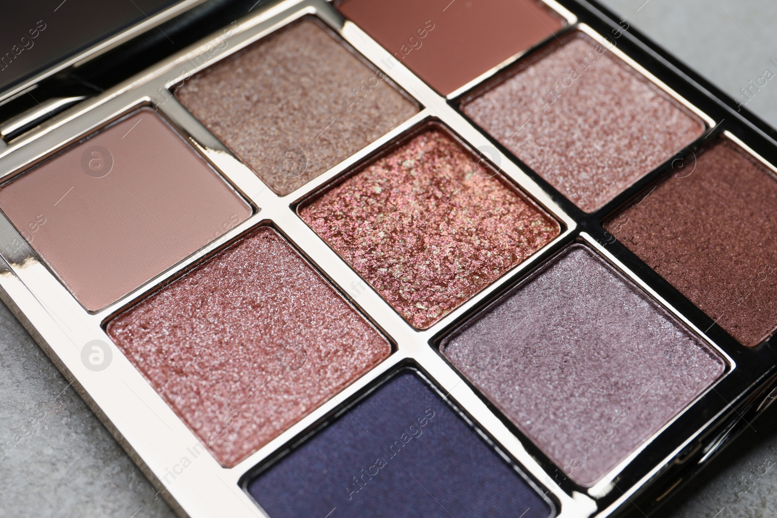 Photo of Beautiful eye shadow palette on grey table, closeup