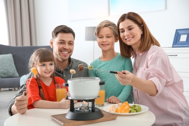 Happy family enjoying fondue dinner at home