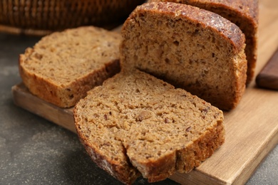Photo of Tasty freshly baked bread on grey table, closeup