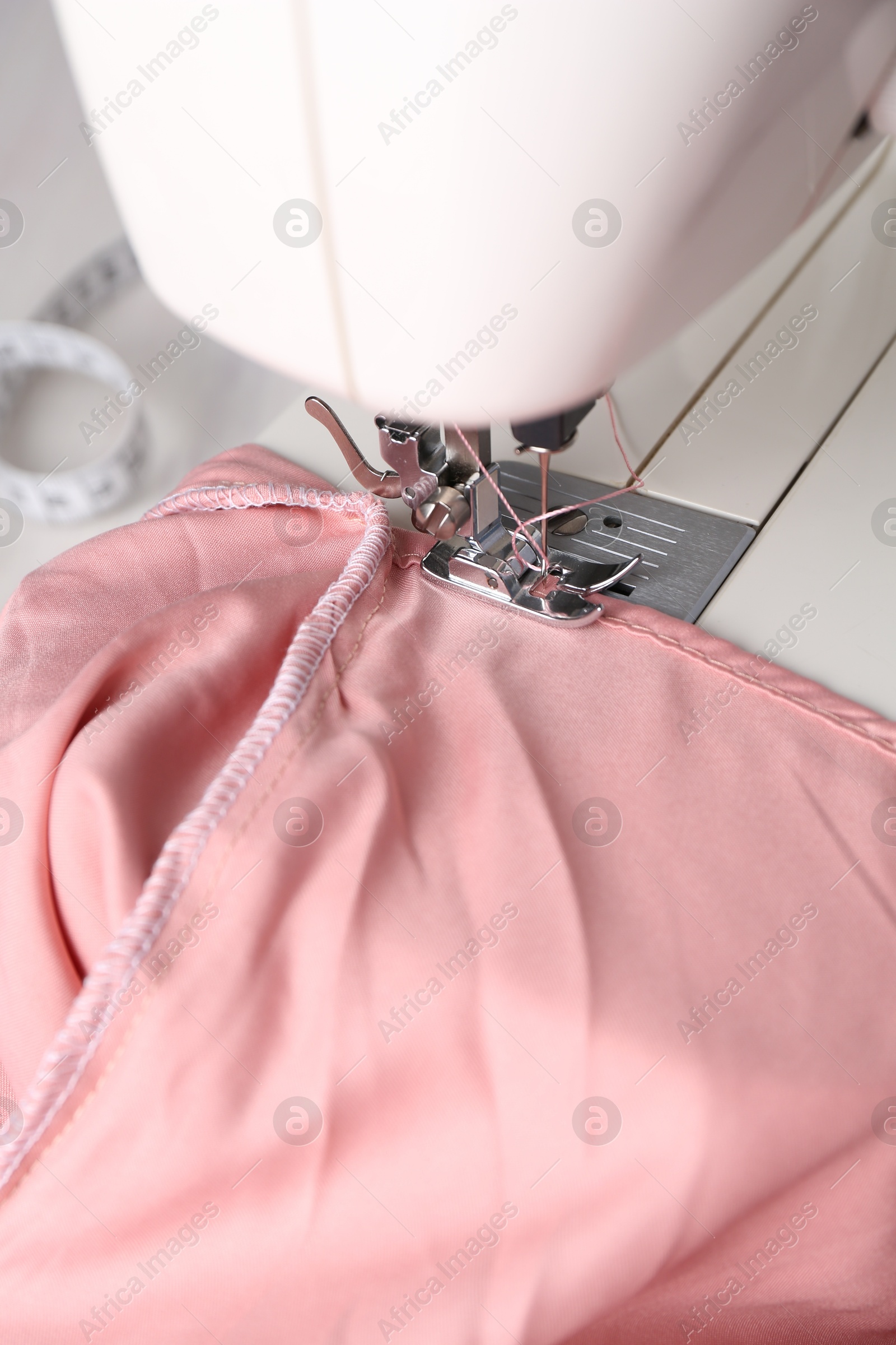 Photo of Sewing machine with color fabric on table, closeup