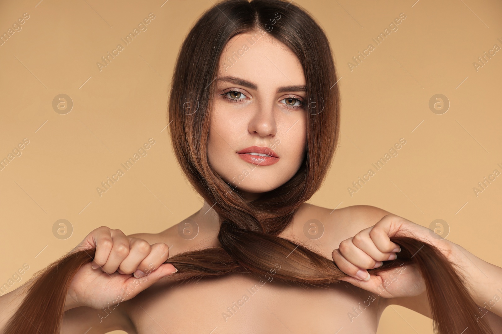 Photo of Young woman with strong healthy hair on beige background