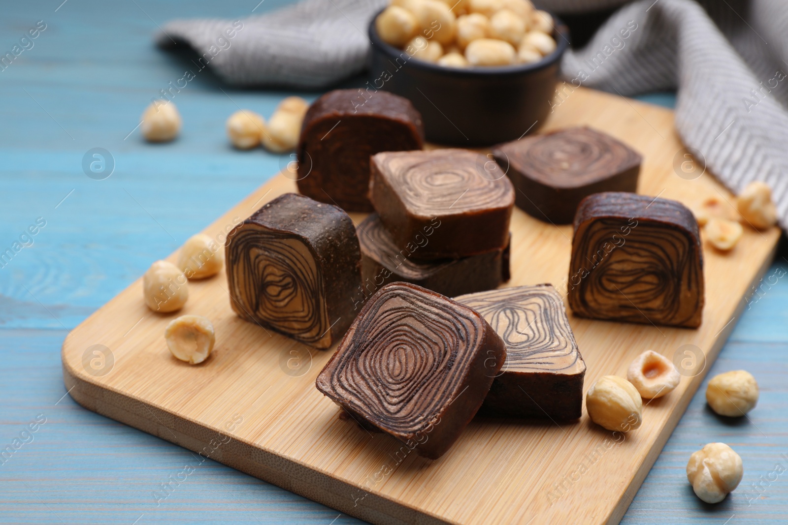 Photo of Tasty chocolate candies on light blue wooden table