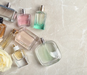 Photo of Perfume bottles on light background, flat lay