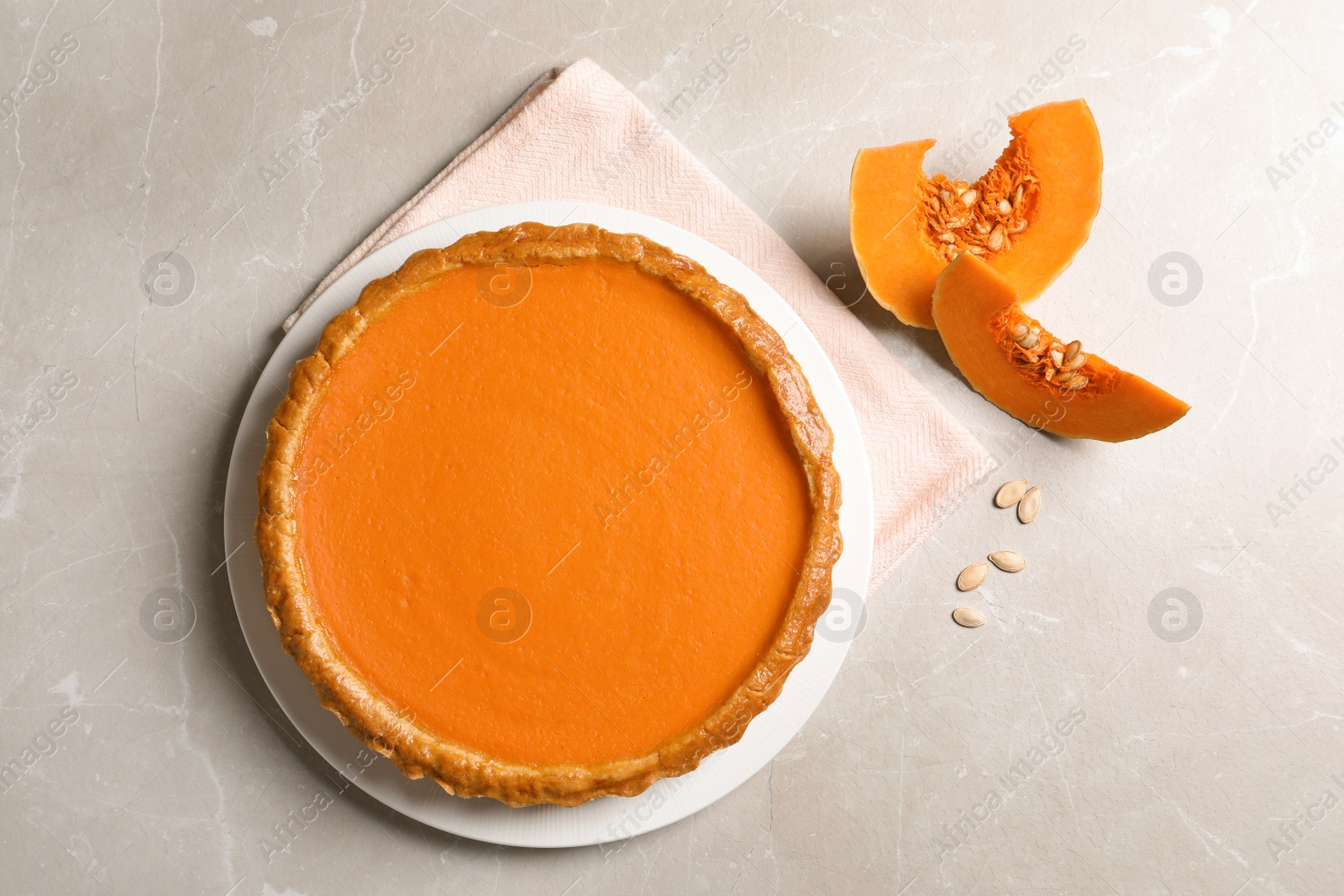 Photo of Composition with fresh delicious homemade pumpkin pie on light background, top view