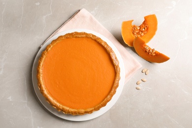 Composition with fresh delicious homemade pumpkin pie on light background, top view