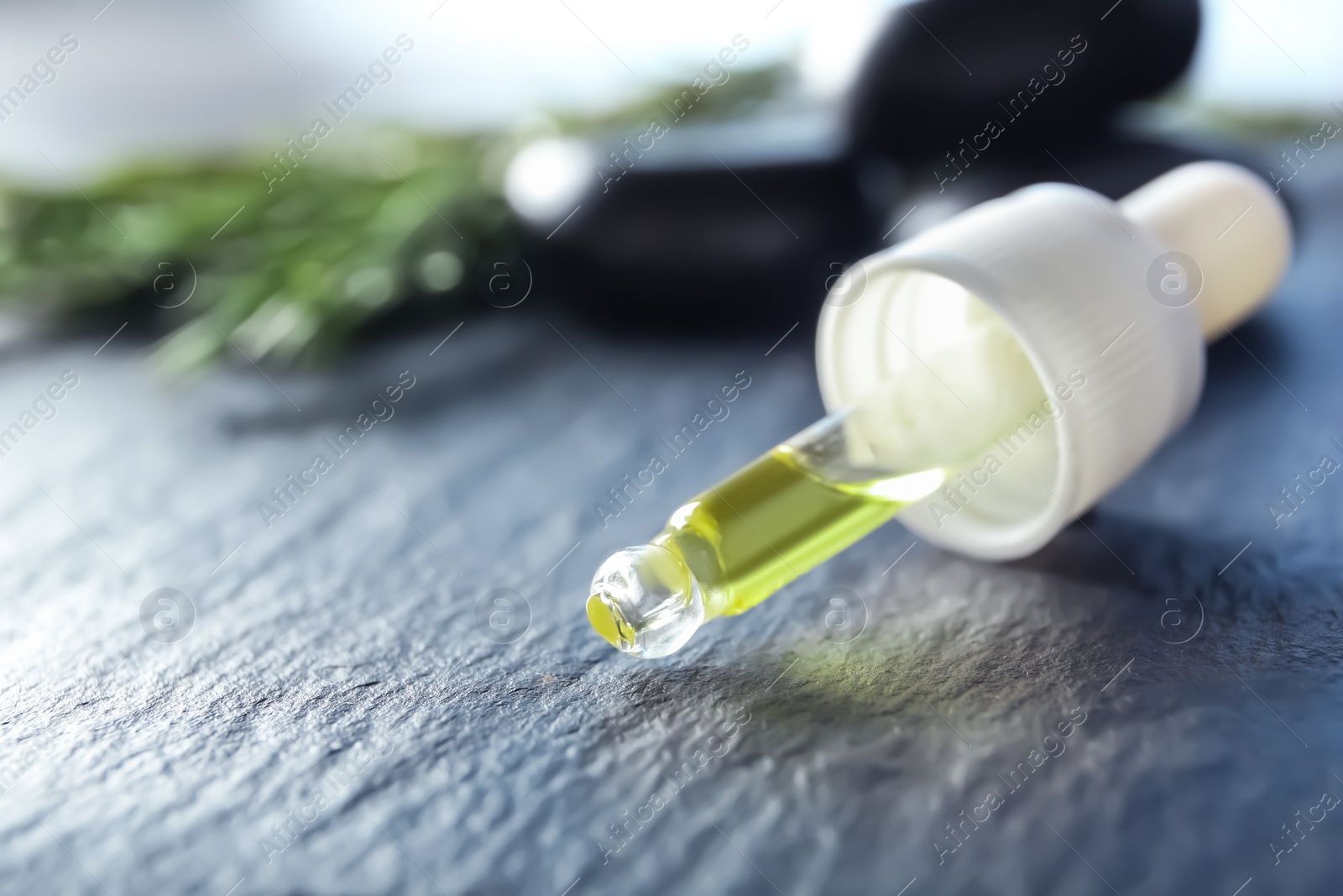 Photo of Pipette with rosemary oil on table, closeup