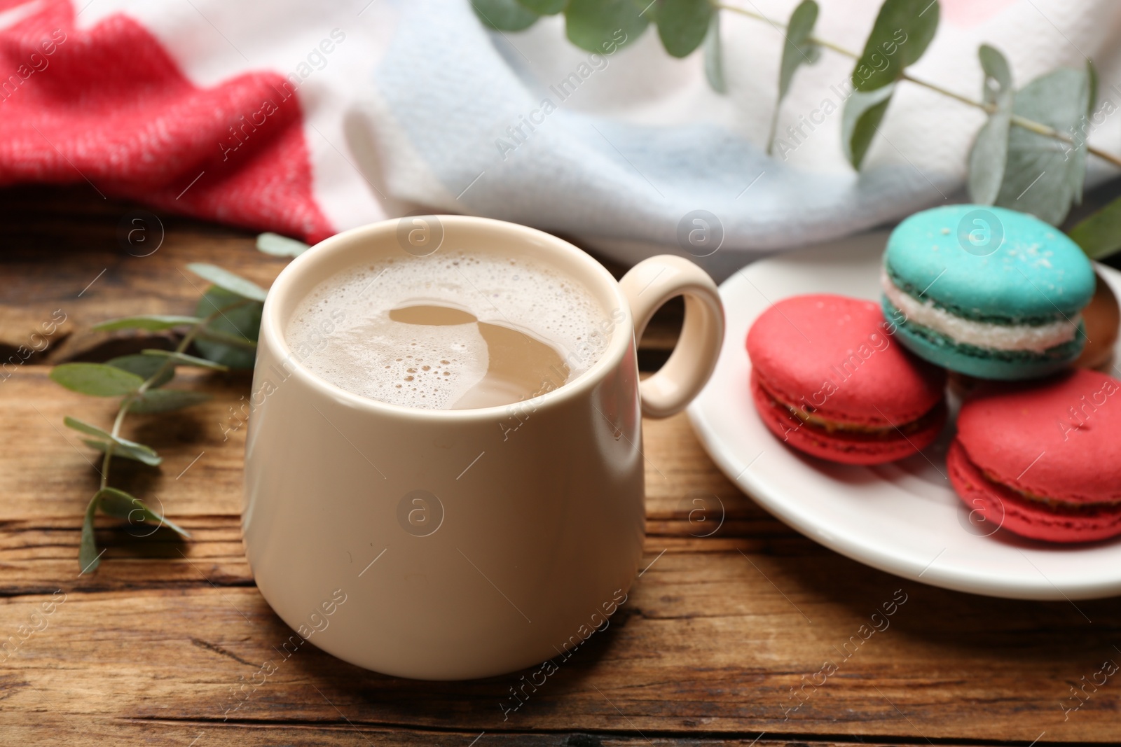 Photo of Composition with coffee and warm plaid on wooden table