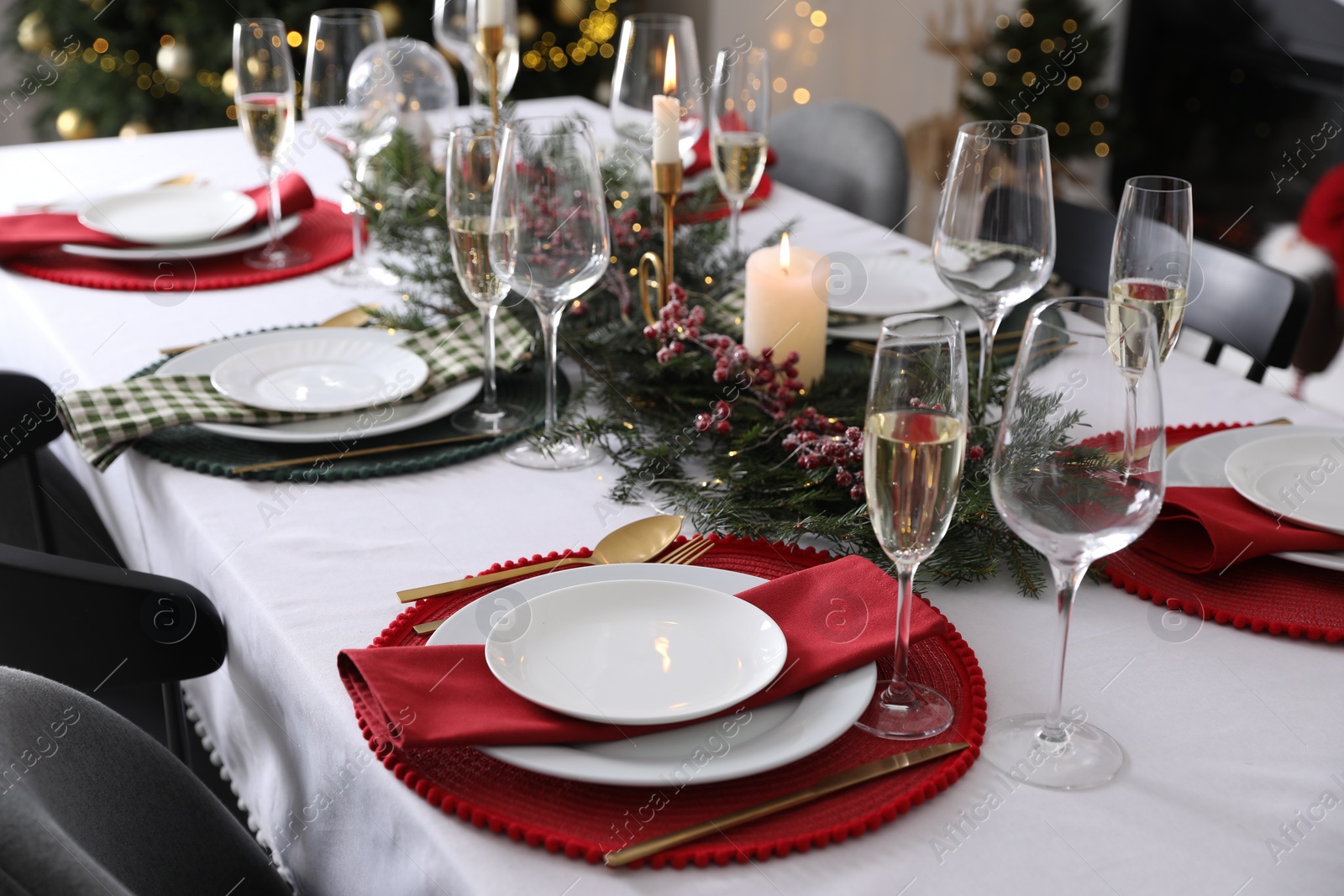 Photo of Christmas table setting with festive decor and dishware indoors