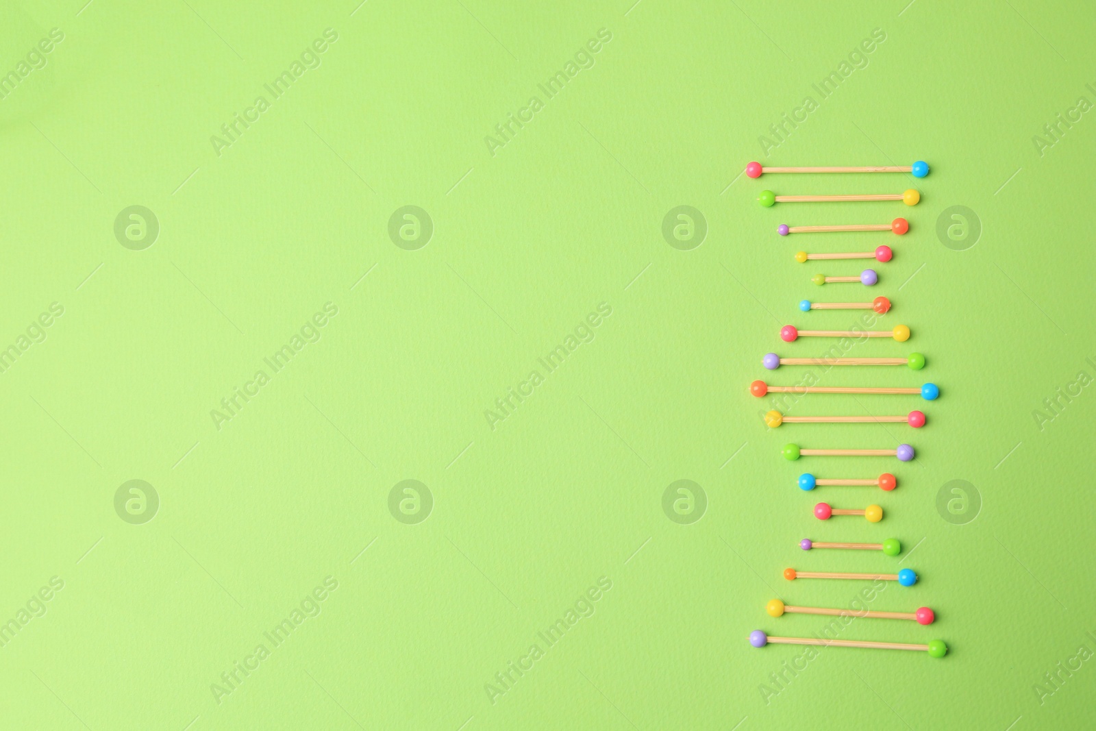 Photo of Model of DNA molecular chain on green background, top view. Space for text