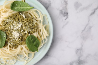 Photo of Tasty pasta with spinach, cheese and sauce on white marble table, top view. Space for text