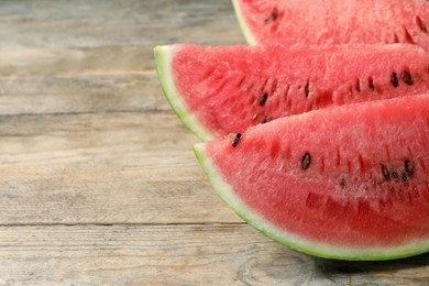 Photo of Slices of tasty ripe watermelon on wooden table, closeup. Space for text