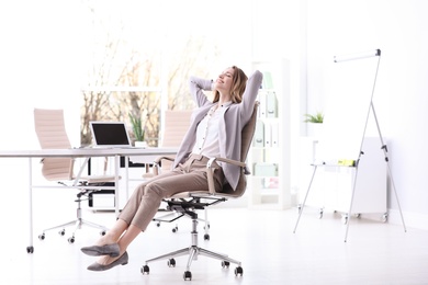 Photo of Young woman sitting in armchair at workplace