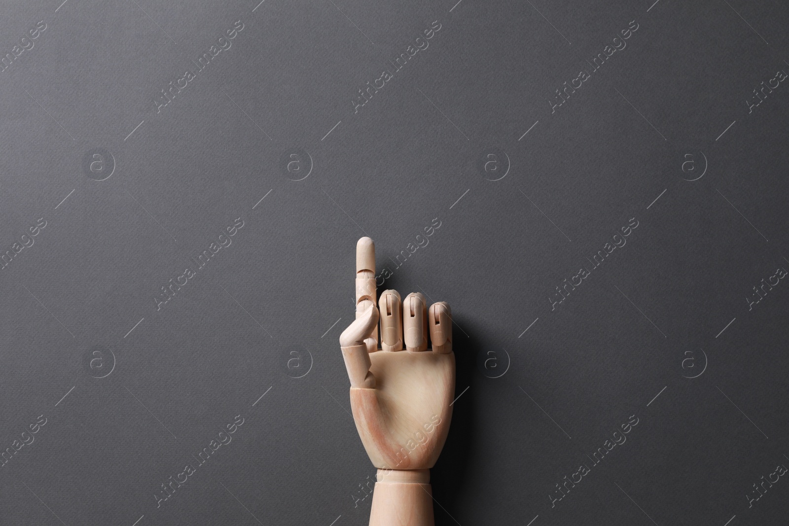 Photo of Wooden mannequin hand on grey background, top view