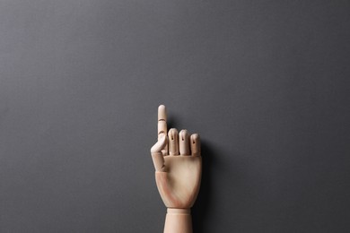 Photo of Wooden mannequin hand on grey background, top view