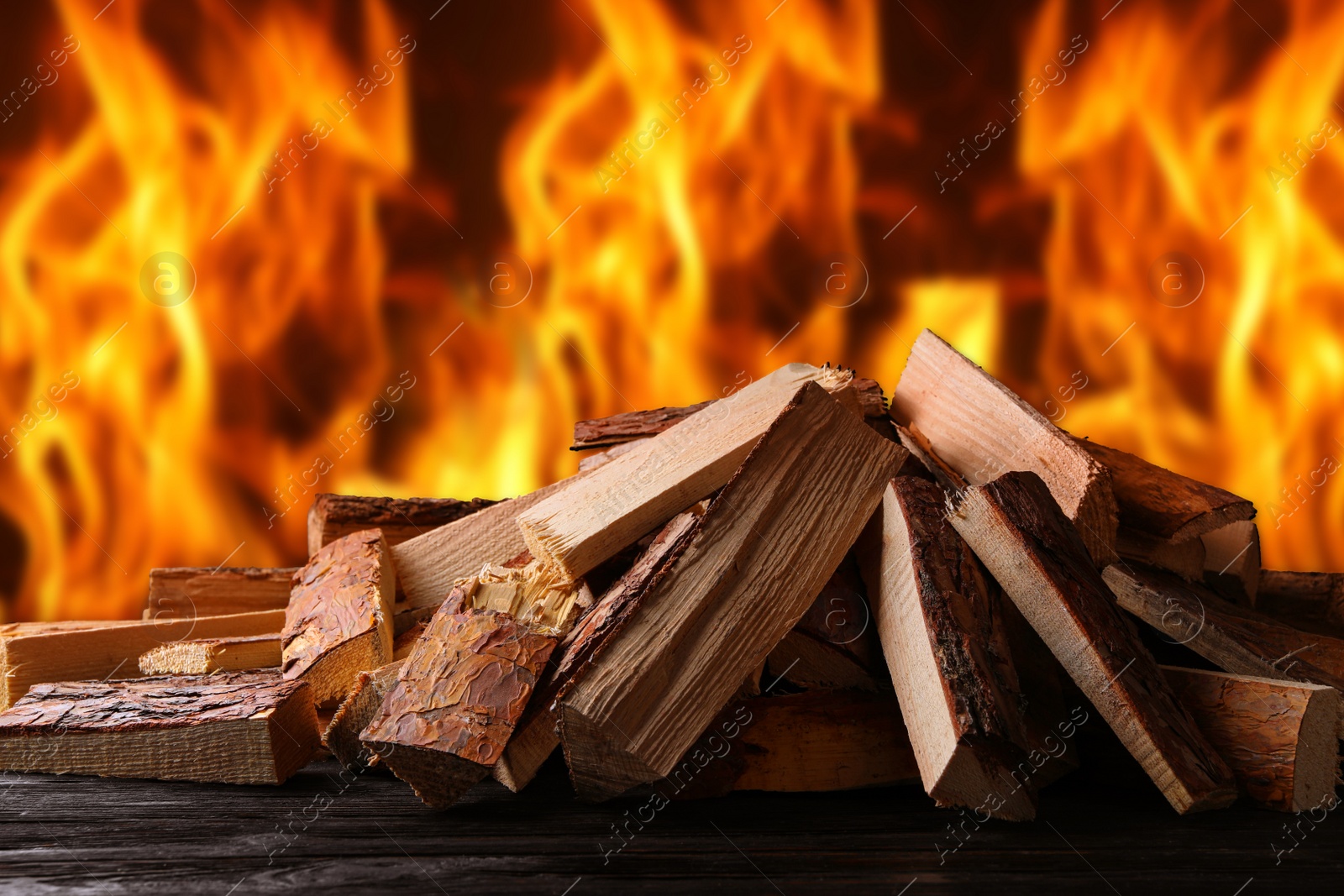 Image of Dry wood and burning fire on background. Cozy atmosphere