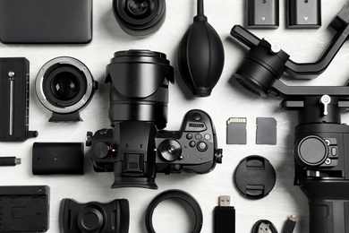 Photo of Flat lay composition with camera and video production equipment on light background