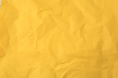 Photo of Sheet of crumpled orange paper as background, top view