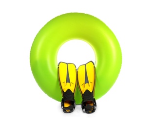 Photo of Bright inflatable ring and flippers on white background