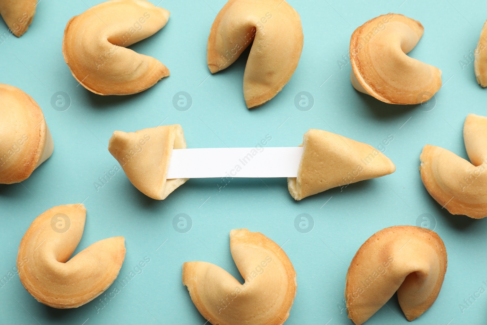 Photo of Tasty fortune cookies with predictions on light blue background, above view. Space for text
