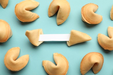 Tasty fortune cookies with predictions on light blue background, above view. Space for text