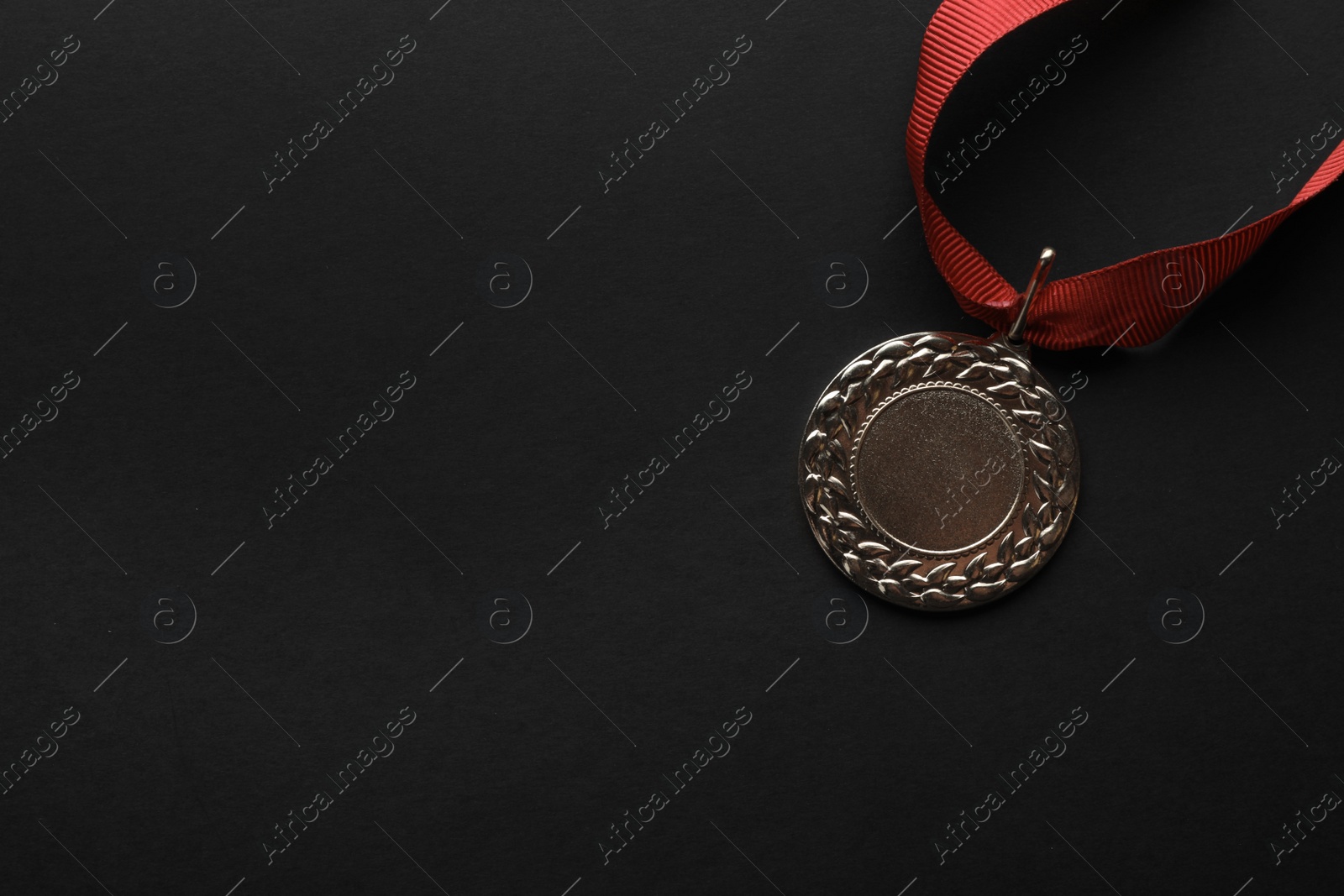 Photo of Gold medal with space for design on black background, top view. Victory concept