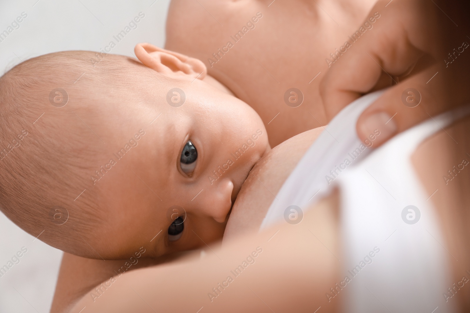 Photo of Young woman breastfeeding her little baby, above view