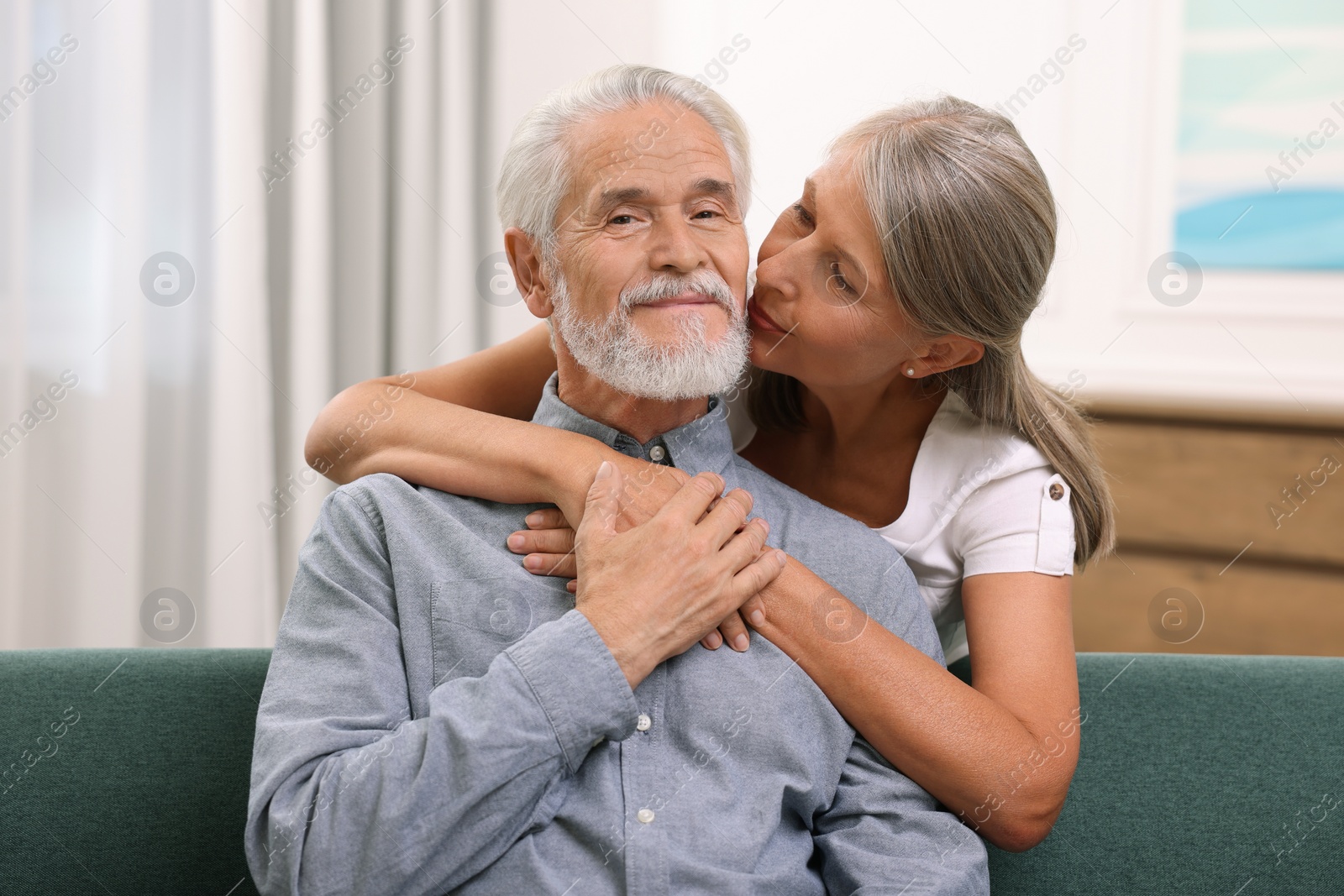 Photo of Senior woman kissing her beloved man indoors