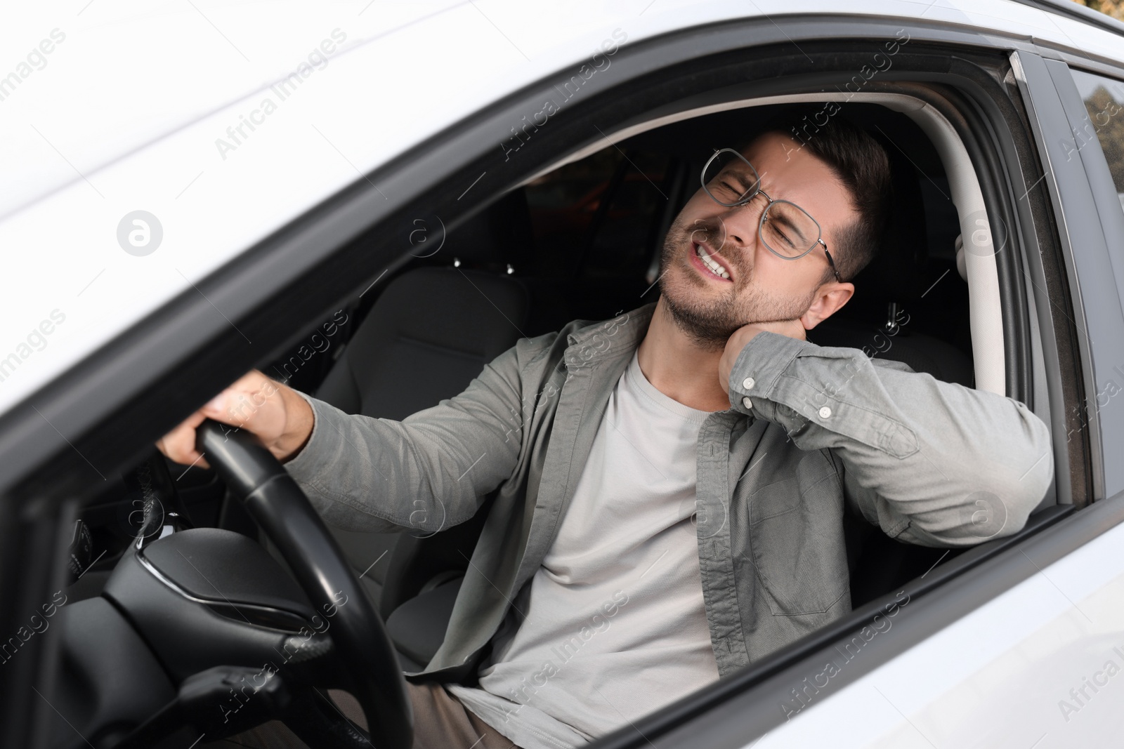 Photo of Man suffering from neck pain in car