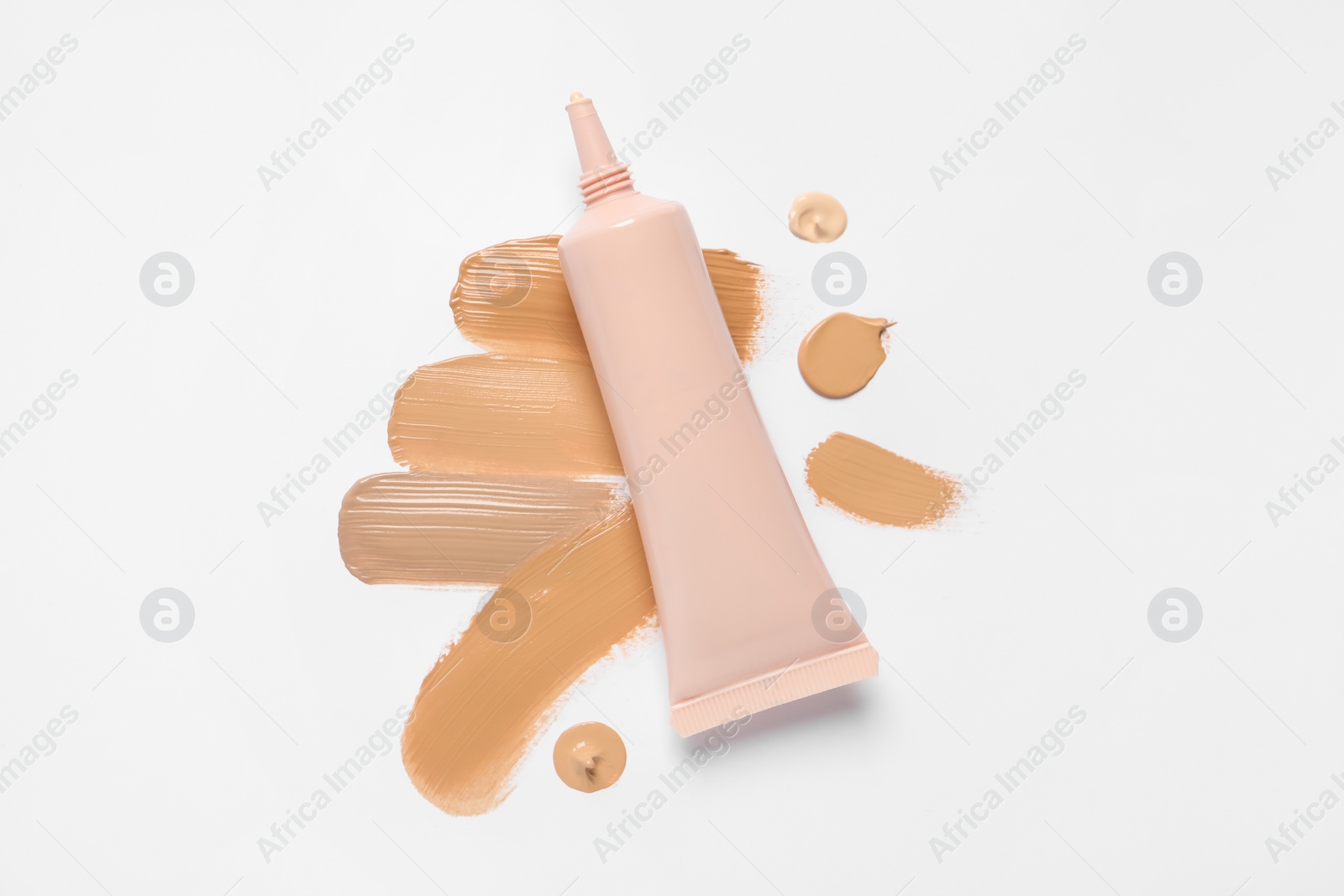 Photo of Liquid foundation and swatches on white background, top view