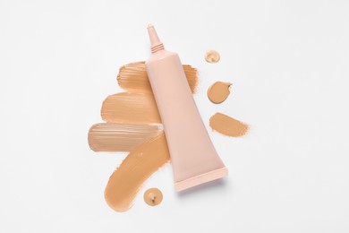 Photo of Liquid foundation and swatches on white background, top view