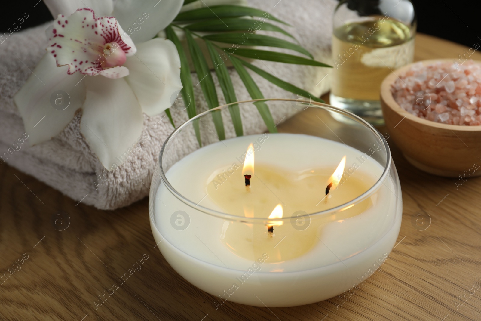 Photo of Composition with different spa products and burning candle on wooden table