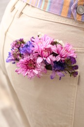 Photo of Woman wearing jeans with flowers in pocket, closeup