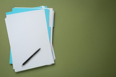 Turquoise files with blank sheets of paper and pen on olive background, top view. Space for text
