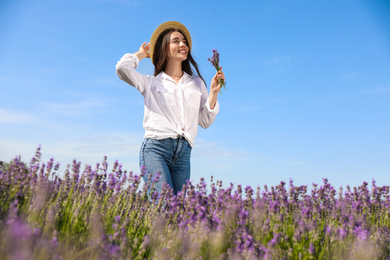 Photo of Young woman with lavender bouquet in field on summer day