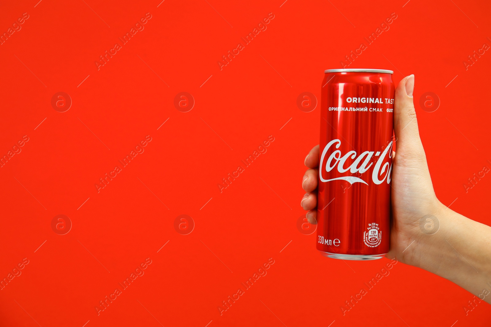 Photo of MYKOLAIV, UKRAINE - NOVEMBER 14, 2018: Woman holding Coca-Cola can on color background. Space for text