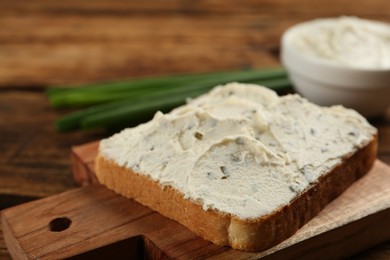 Photo of Delicious sandwich with cream cheese on wooden table, closeup