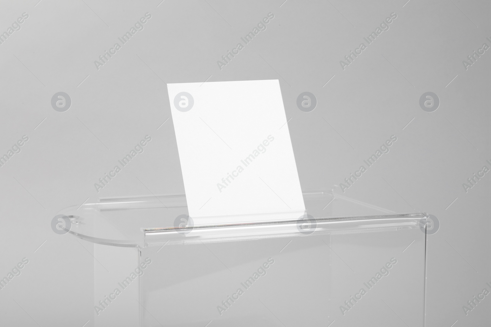 Photo of Ballot box with vote on light grey background, closeup. Election time