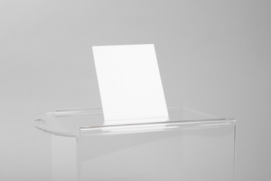 Photo of Ballot box with vote on light grey background, closeup. Election time