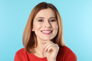 Smiling woman with perfect teeth on color background